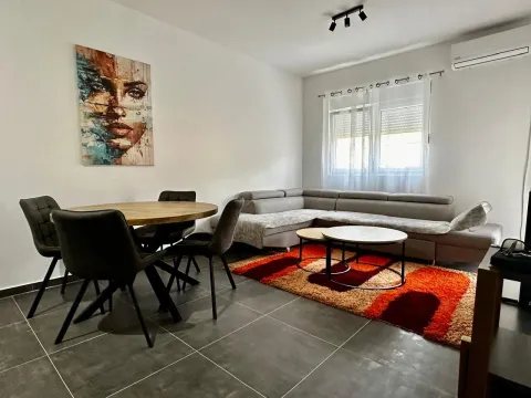 Dnevni boravak sa garniturom, trpezarijskim stolom i umjetničkom slikom na zidu. - image 2