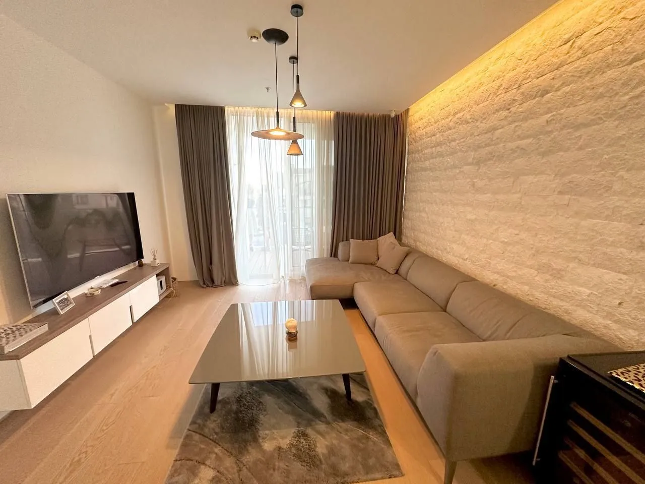 Modern and tidy living room with a large corner sofa and television.