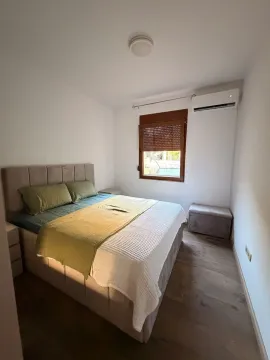 Svjetla spavaća soba sa bračnim krevetom, prozorom i klima uređajem. - image 3