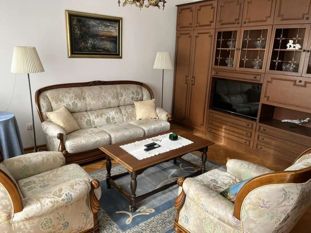 Living room with a seating set and a wooden wall unit.