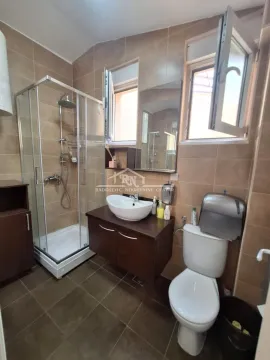 Kupatilo opremljeno tuš kabinom, umivaonikom sa ormarićem i toaletom. - image 20