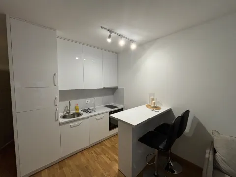 Modern white kitchen with a breakfast bar and black bar stools. - image 3