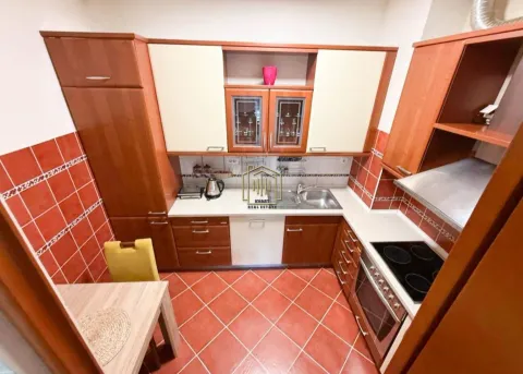 Kitchen with wooden cabinetry, a sink, and a built-in oven. - image 4