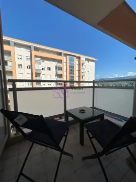 Namješten balkon sa stolom i stolicama i pogledom na okolne zgrade. - image 10
