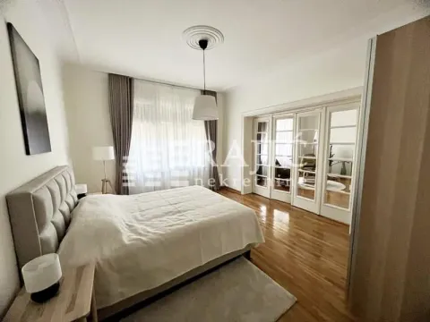 Spacious bedroom with a large double bed and wooden flooring. - image 5