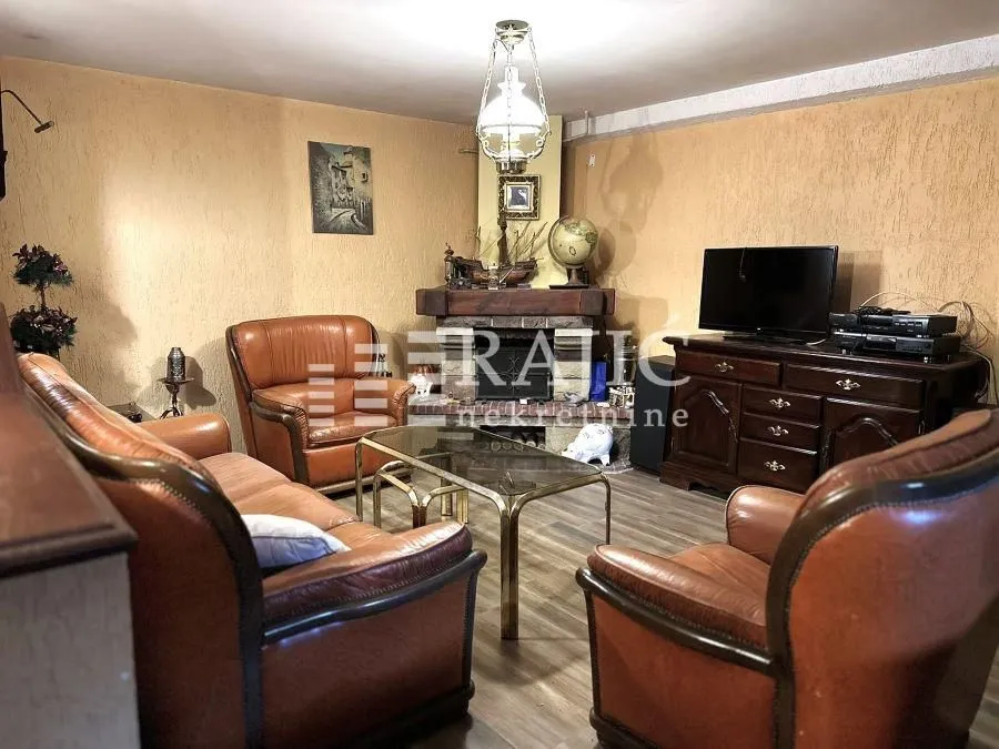 Living room with leather seating and a fireplace.