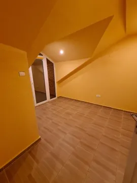 Prazna potkrovna prostorija sa žutim zidovima. - image 10