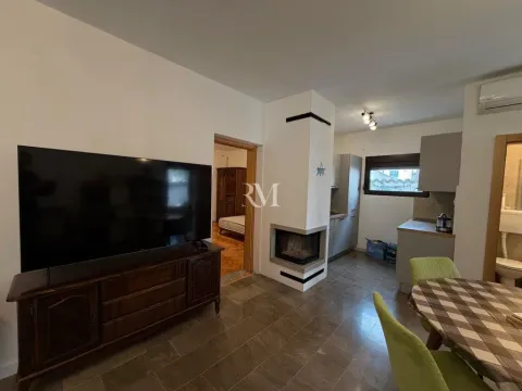 Living room with a fireplace and dining area. - image 7