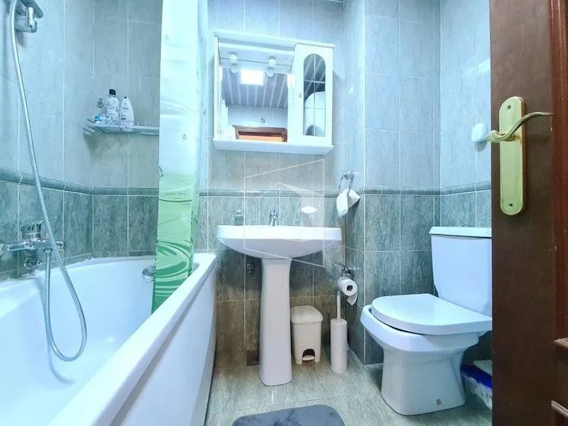 Small bathroom with a bathtub, sink, and toilet.