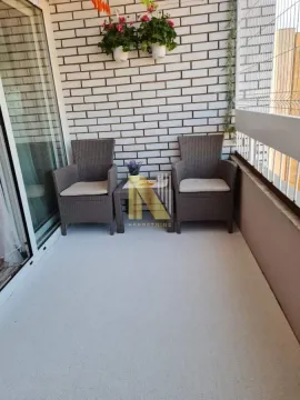 Manji namešten balkon sa garniturom za sedenje i ukrasnim cvećem na zidu. - image 7