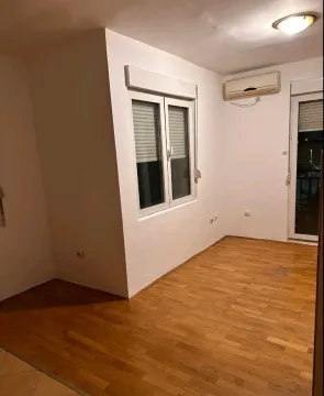 An empty, bright room with wooden flooring and an air conditioning unit. - image 6