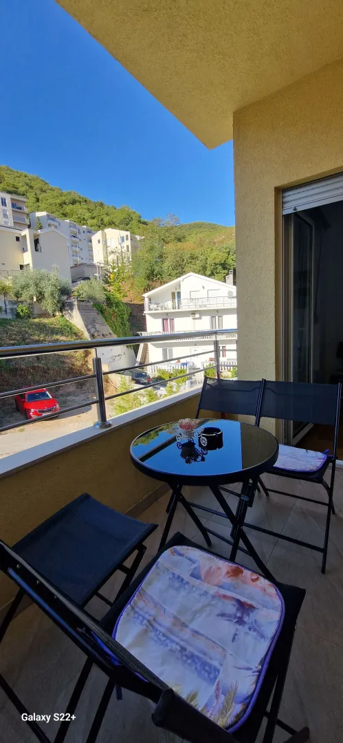 Furnished terrace with a table and chairs and a view of the surroundings.