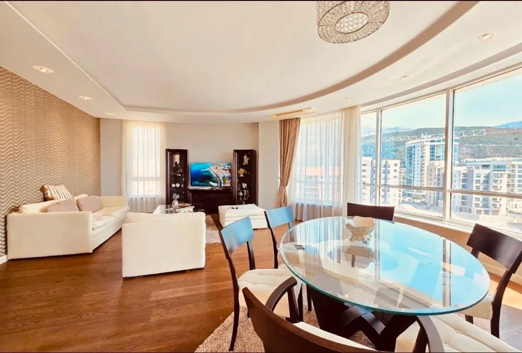 Spacious living room with dining area and large windows.