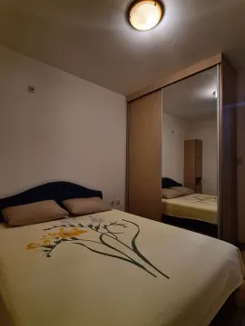 Bedroom with a double bed and a large wardrobe with a mirror. - image 2