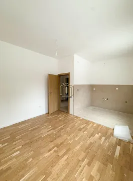 Prazna prostorija sa drvenim podom i pripremljenim dijelom za kuhinju. - image 5