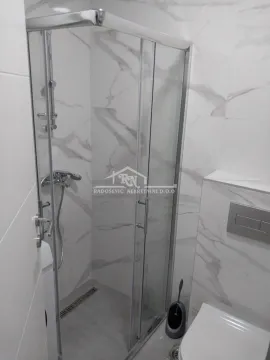 Moderno kupatilo sa tuš kabinom obloženom pločicama sa efektom mermera. - image 12