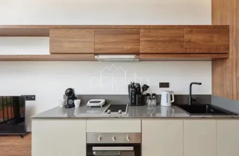 Modern kitchen with wooden cabinetry and built-in appliances. - image 8