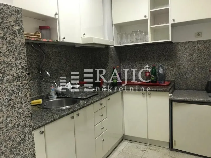 Small kitchen with white cabinets and granite countertops.