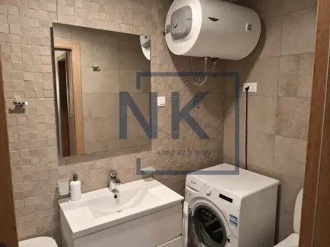 Bathroom with a washbasin, mirror, washing machine, and water heater. - image 10