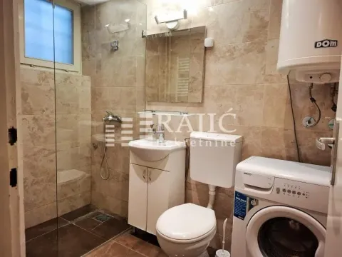 Smaller tiled bathroom with a shower cabin, washbasin, toilet, and washing machine. - image 17