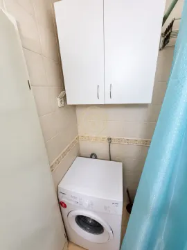 Kupatilo sa veš mašinom i belim zidnim ormarićem. - image 7