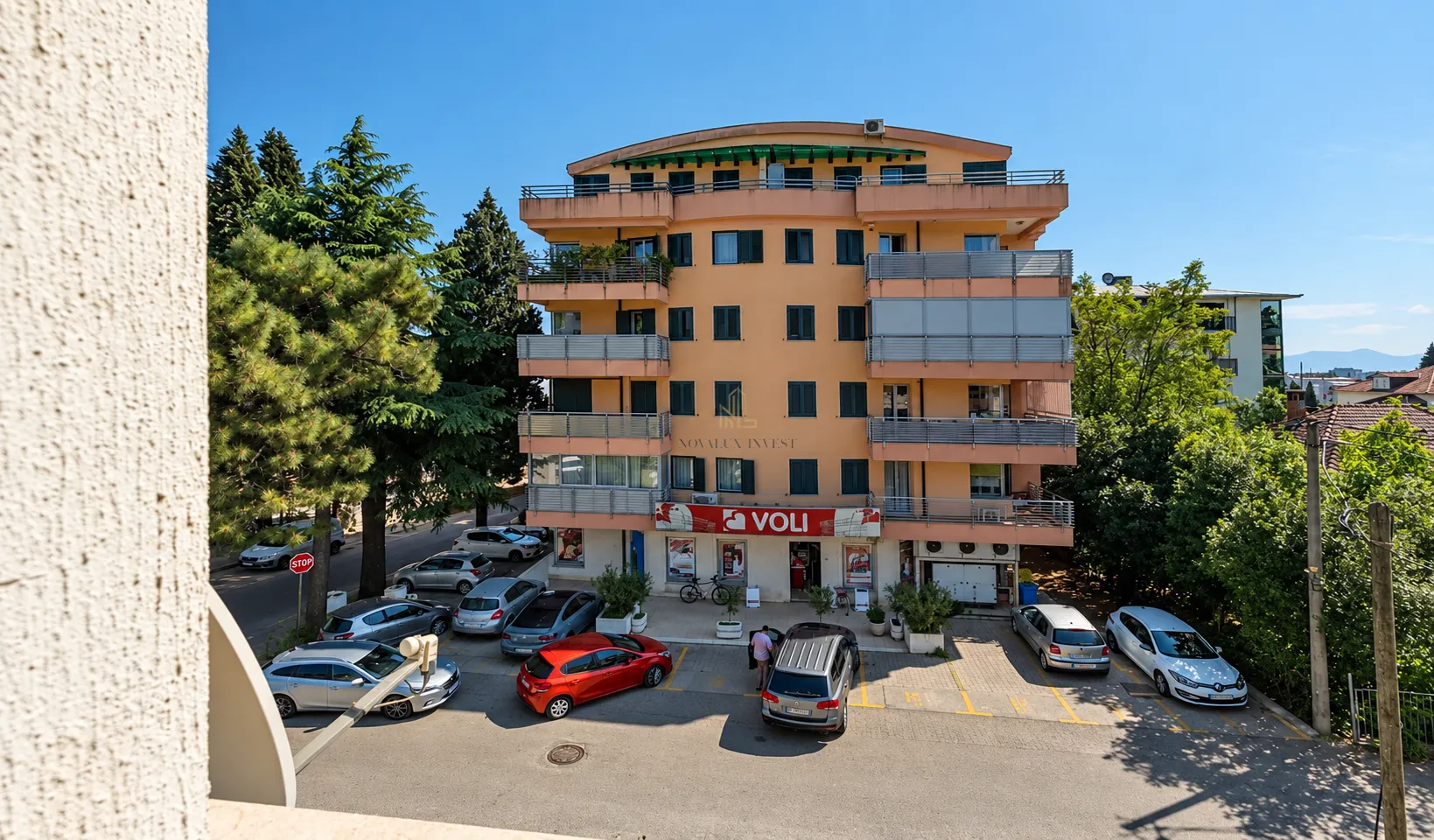 View of the building exterior facade with parking space and surroundings.