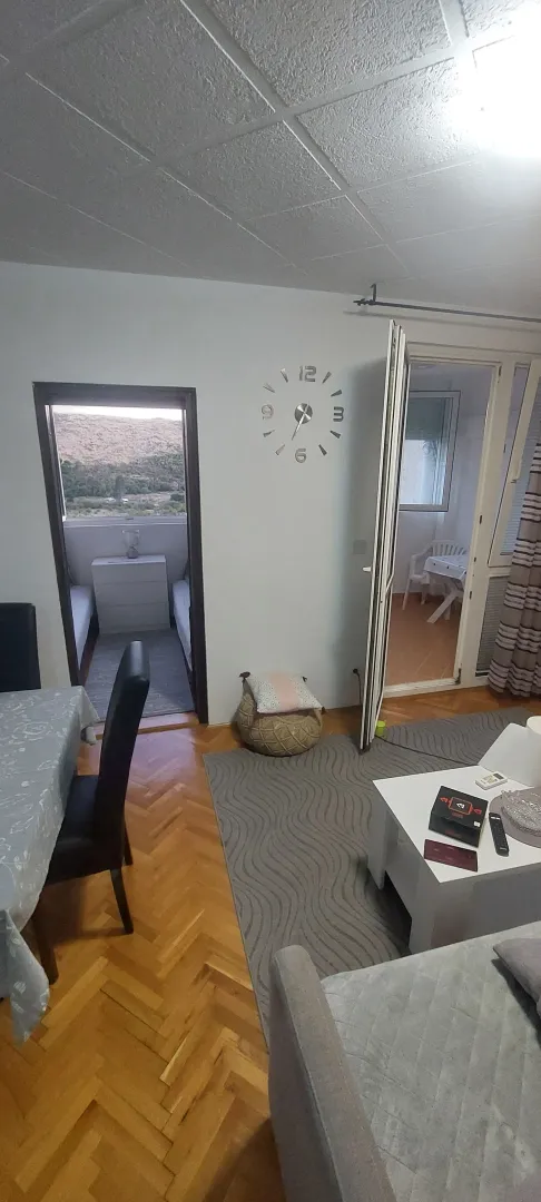 Dnevni boravak sa trpezarijskim stolom, parketom i izlazom na terasu.