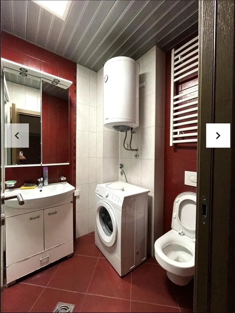 Bathroom equipped with a washbasin, washing machine, water heater, and toilet.