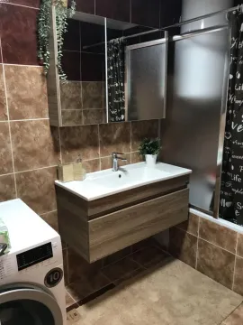 Bathroom with a sink, mirror, and shower enclosure. - image 7