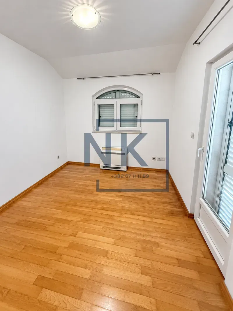 Empty room with wooden flooring, white walls, and a window.