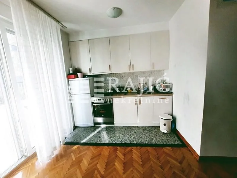 Small kitchen with light cabinetry and parquet flooring.
