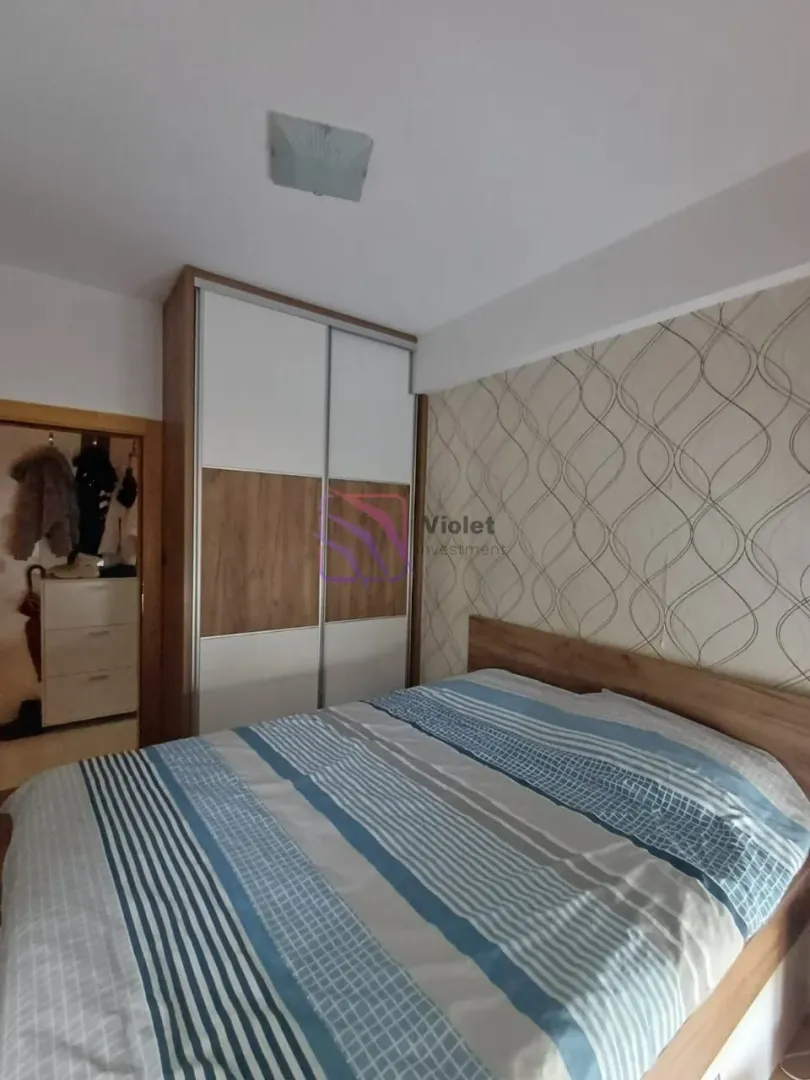 Furnished bedroom with a double bed and a built-in wardrobe.