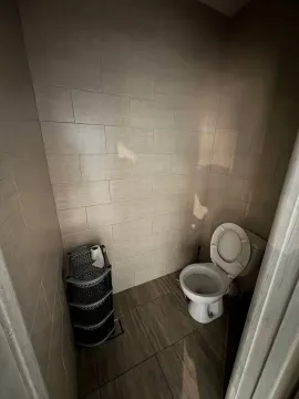 Small bathroom with toilet and tiled walls. - image 11