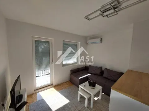 Manja dnevna soba sa garniturom, stočićem, televizorom i izlazom na terasu. - image 2