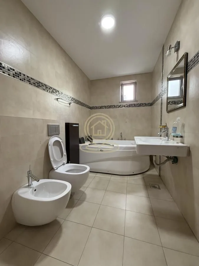 Spacious bathroom equipped with sanitary ware and a bathtub.