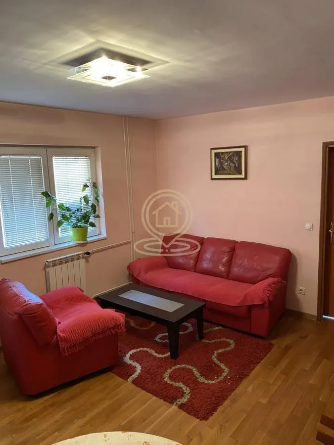 Living room with a red sofa set, coffee table, and rug.
