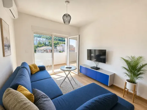 Living room with a blue sectional sofa, TV, and access to the terrace. - image 3