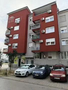 Pogled na spoljašnjost stambene zgrade sa parkingom ispred. - image 2