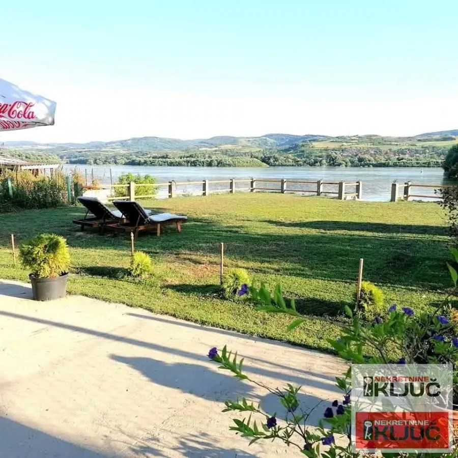 Yard with a river view and sun loungers.