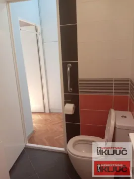 Pogled na kupatilo sa toaletom i pločicama u braon tonovima. - image 9
