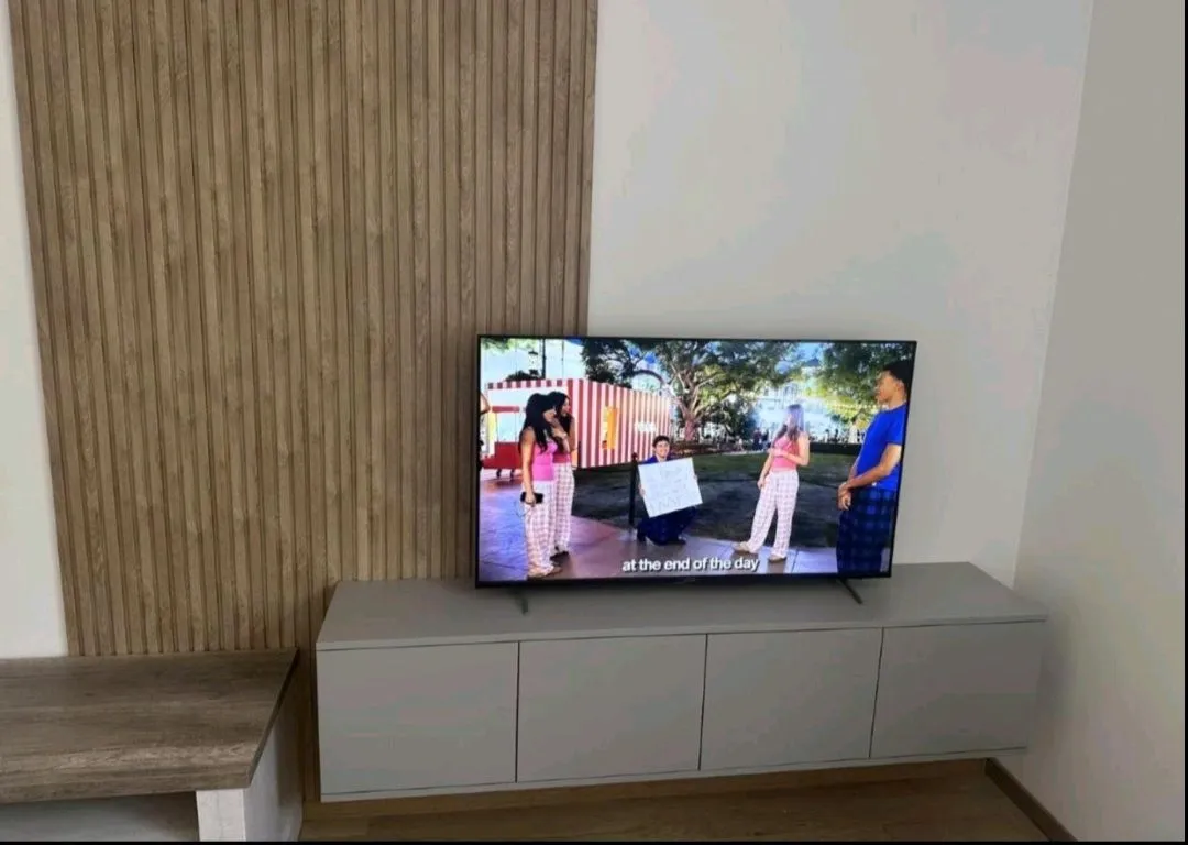 Dnevna soba sa televizorom i modernom komodom.