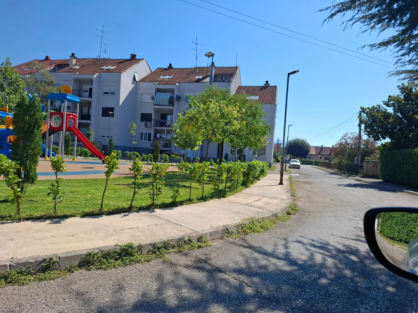 View of the apartment building and children's playground in front of the entrance.