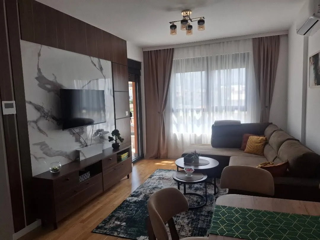 Moderan i svijetao dnevni boravak sa garniturom i TV komodom.