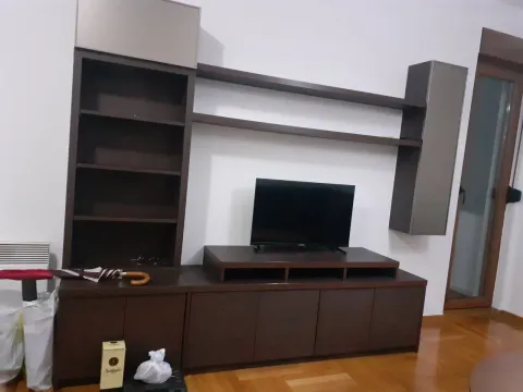 Living room featuring a dark wooden TV unit and wall shelves. - image 6