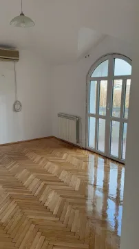 An empty room with polished parquet floor and balcony access. - image 17
