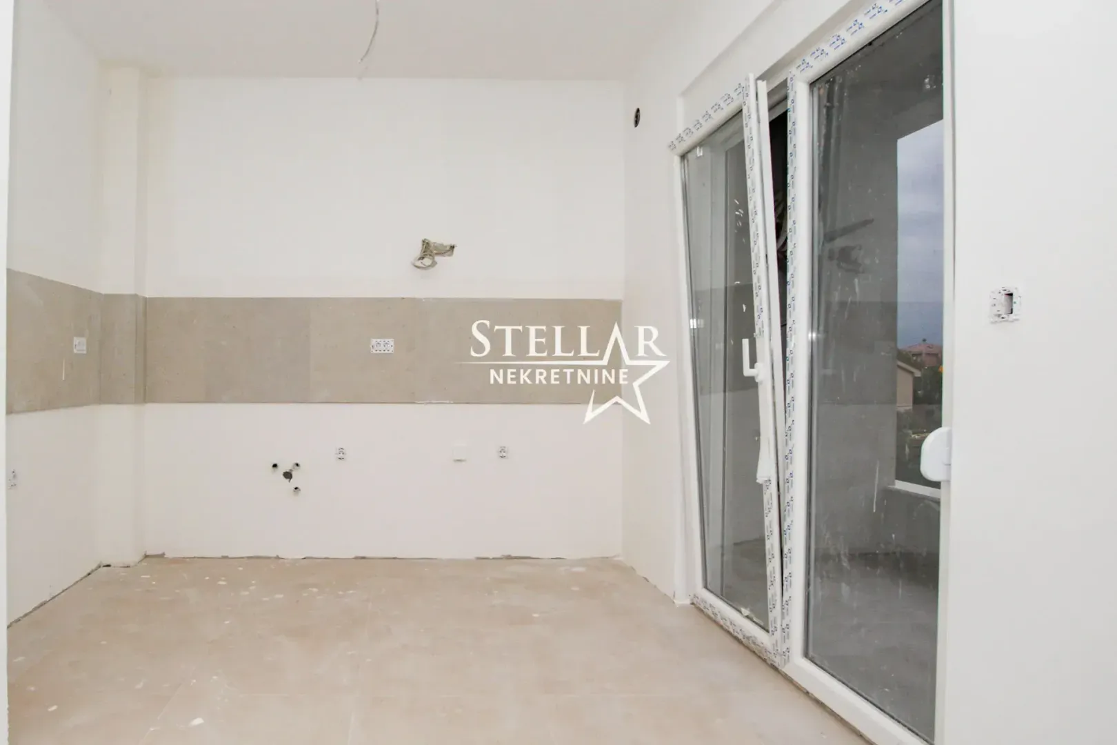 Unfurnished room under renovation with balcony doors.