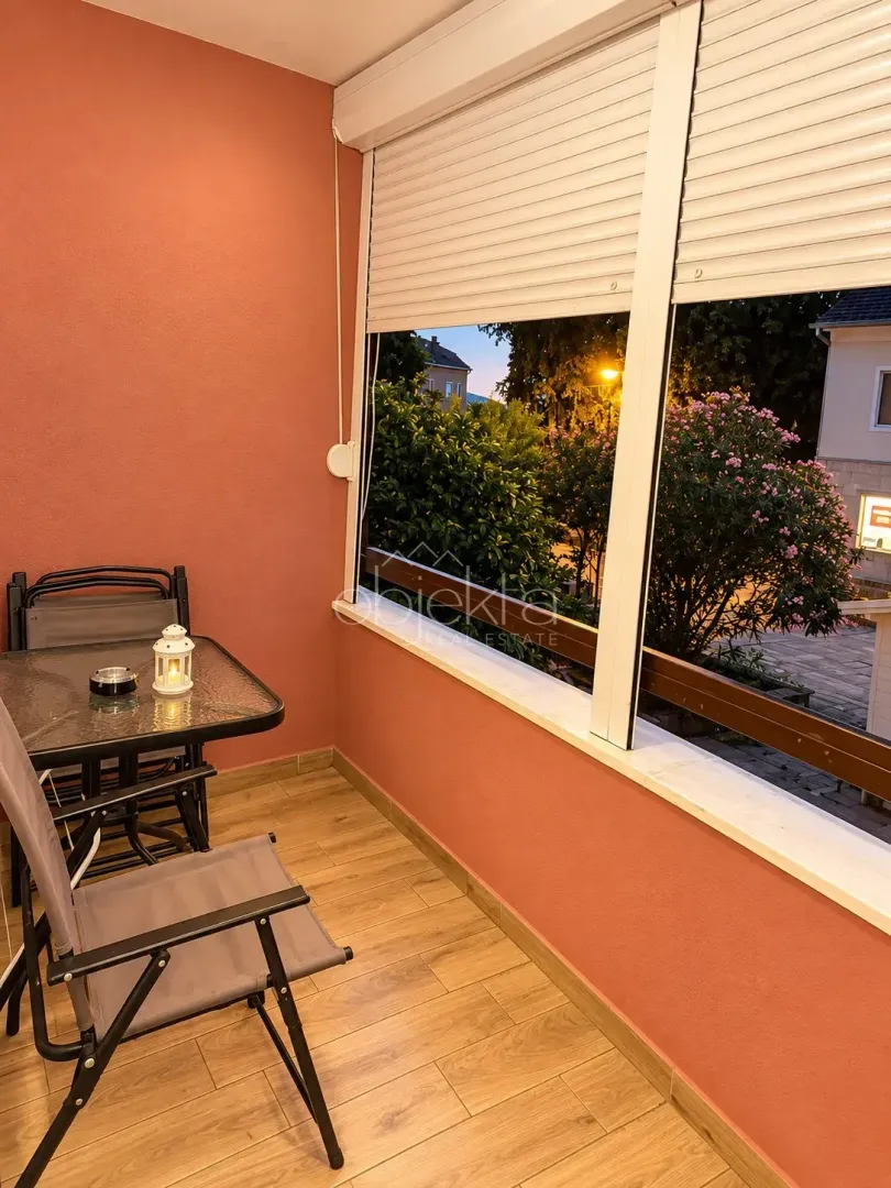 Enclosed balcony with seating furniture and a view of the surroundings.