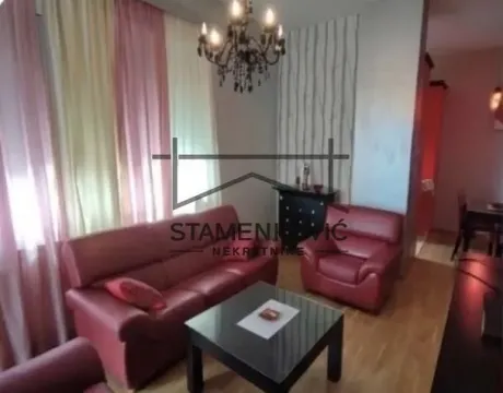 Dnevna soba sa crvenom kožnom garniturom, stočićem i lusterom. - image 3