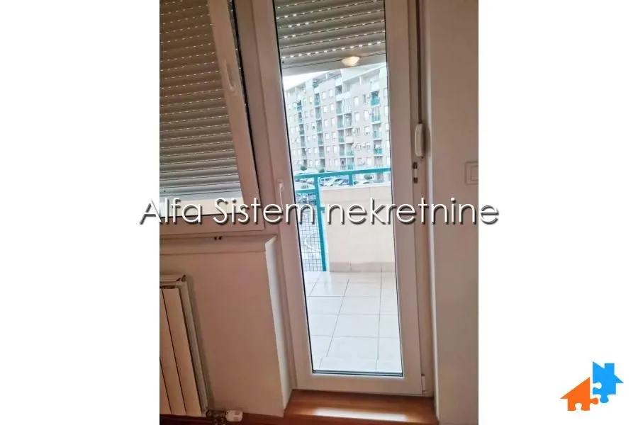 View through the balcony door to the terrace and surrounding buildings.