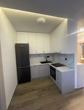 Moderna kuhinja sa bijelim elementima, crnim frižiderom i ugrađenom rernom. - image 3